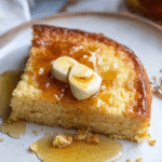 Stacked slices of golden brown air fryer cornbread on a ceramic plate