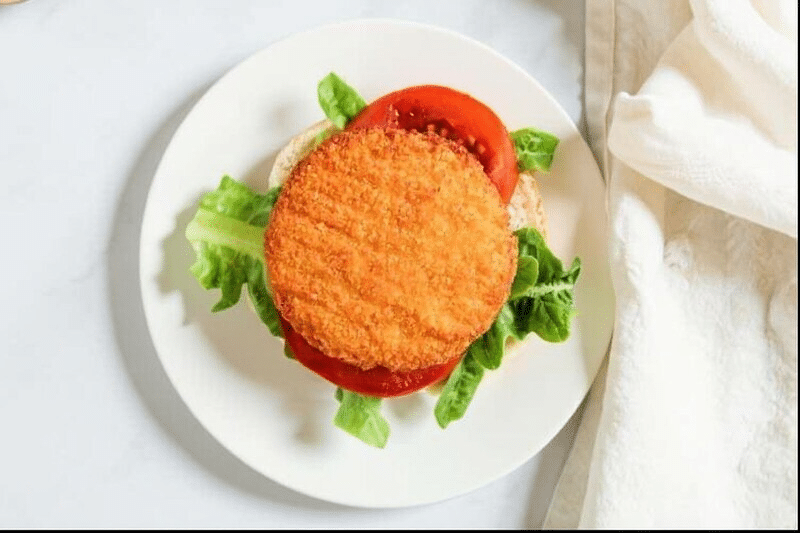 Breaded chicken patty on a sandwich with lettuce and tomato
