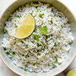 Cooked quick cilantro lime rice with lime wedge and cilantro on top